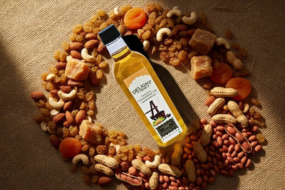  Groundnut oil bottle with dry fruits, jaggery, and fresh peanuts on burlap cloth 