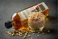 Traditional brass mustard oil container, mustard seeds, oil cake on rustic wooden table